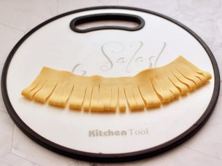 凉拌菊花豆皮,再用刀均匀的切成三毫米左右的细条，上面的地方不要切断。