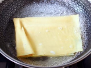 凉拌菊花豆皮,锅中倒入适量清水烧开后，放入豆皮进行焯水，看见豆皮变软变白，即可捞出过冷水后沥干。