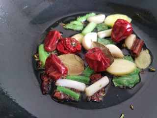 红焖牛肉,锅里放油，加入葱、姜、蒜、花椒、八角、辣椒炒香。