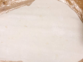 红糖麻糍,菜板上放一个保鲜袋，将糯米团放在上面，撒点干糯米粉，将糯米团擀成长方形薄片