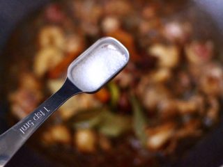 鸡腿炖香菇,锅中加入适量的盐调味。