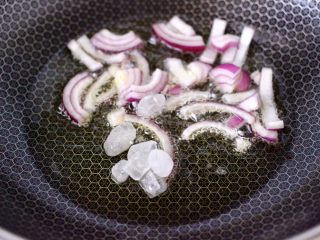鸡腿炖香菇,锅烧热倒入花生油烧热，放入洋葱爆香，加入冰糖炒至焦糖色后。
