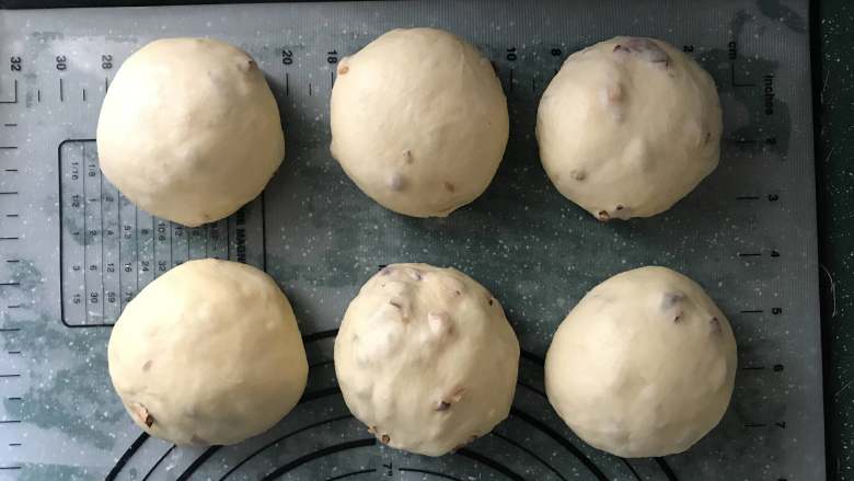 红枣面包,取出面团倒在案板上，轻轻拍打排气，称重分成6等份，揉圆