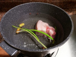 蒜苗炒香干,锅中加入适量清水，放入洗净的五花肉和几颗花椒、生姜、小葱煮15分钟。