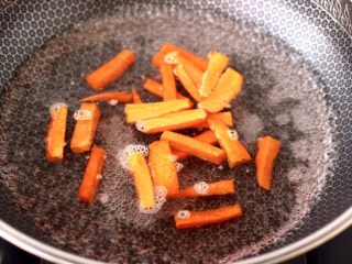 蒜苗炒猪肝,锅中倒入适量的清水烧开，加入胡萝卜条进行焯水，看见胡萝卜条变软捞出沥干水分。