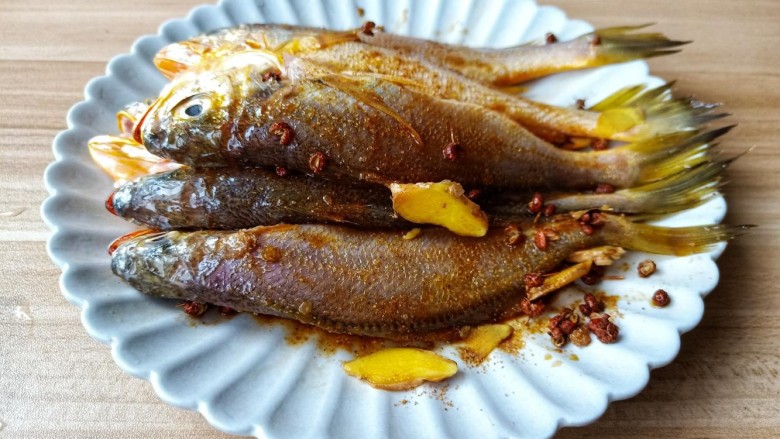 酥炸小黄鱼,轻轻抓鱼，让调味料裹满鱼身，腌制15分钟入味。