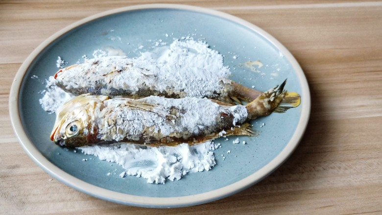 酥炸小黄鱼,盘里放一点玉米淀粉，放入鱼裹一层淀粉。