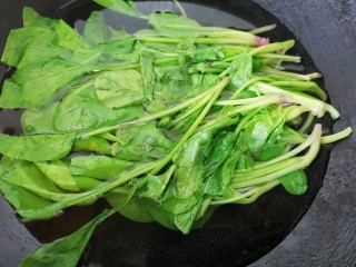 菠菜拌花生米,将水烧开放入菠菜焯下水去除草酸