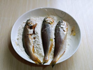 酥炸小黄鱼,将小黄鱼均匀裹上一层干面粉。