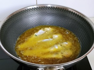 酥炸小黄鱼,待油温6成热时，下去裹好面粉的小鱼，切记，不要去动它，先大火炸鱼，待鱼定型后，转小火慢炸。