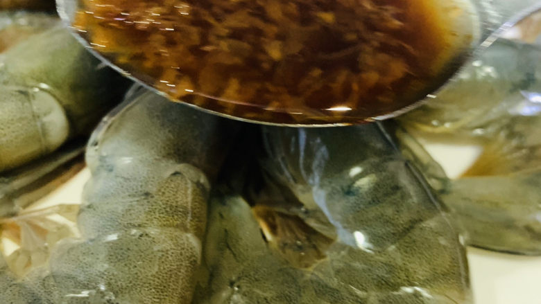 蒜蓉蒸大虾,用勺子，把炒好的蒜蓉浇在每只虾上；