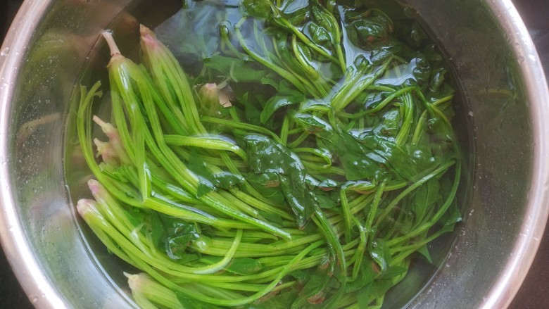 菠菜拌花生米,把菠菜捞出放入冷水中，多过几遍冷水，使菠菜保持翠绿