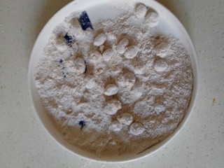 多味花生,晃动盘子，使花生米裹均匀面粉，分次少量裹面粉