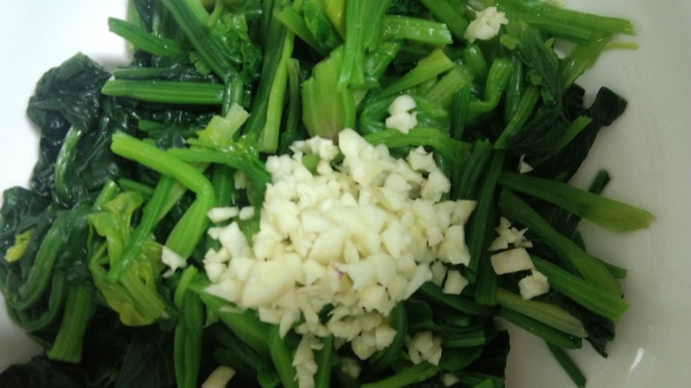 菠菜拌花生米,焯好的菠菜放入蒜。