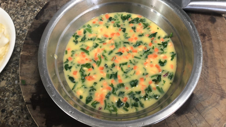 菠菜鸡蛋羹➕黄花丛畔绿尊前,把胡萝卜末也均匀的撒在碗中，蒙上保鲜膜，戳几个小控备用