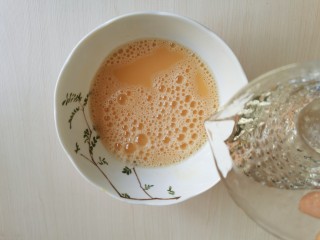 菠菜鸡蛋羹,往搅打好的蛋液中倒入适量的水，再一次搅打均匀。