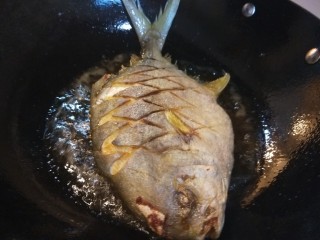炖草鱼,锅中倒入适量油烧热，炸制两面金黄捞出来控油。