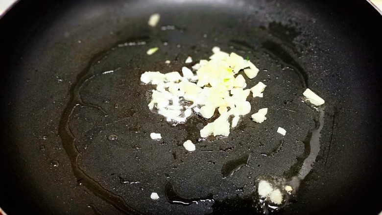 蒜苗炒香干,锅中放入适量油，炒香蒜碎。