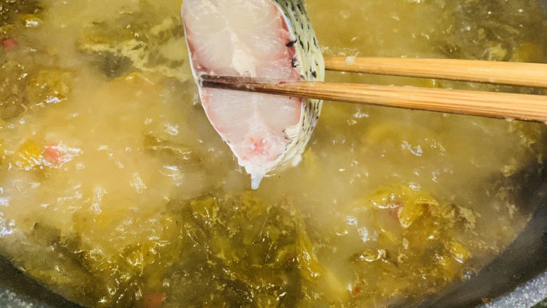 炖草鱼,用筷子夹起鱼块，一块块放入，刚才腌鱼汁就不要了；