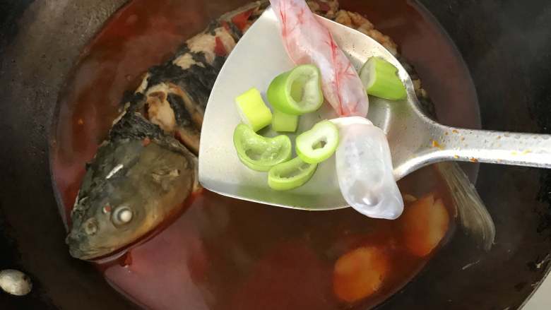 炖草鱼,炖到锅中鱼肉变色，汤汁渐少时，将鱼泡和留下的葱段放入锅中，盖上锅盖，进一步去腥增香