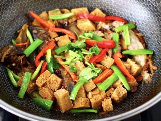 海杂鱼酱焖冻豆腐,加入青红辣椒条，看见断生变色撒上香菜段即可关火。