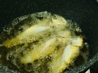 酥炸小黄鱼,油温五成热，把裹好面糊的小黄鱼放油锅里；