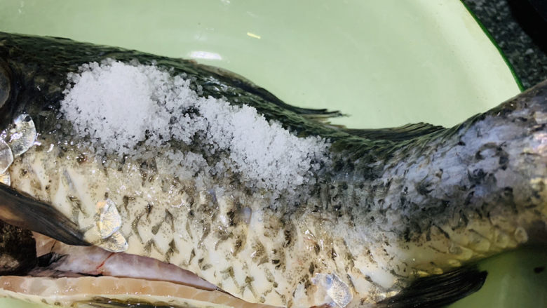 木瓜鲫鱼汤,鱼表面撒上少许盐，用剪刀反方向刮表层去粘液和鱼鳞；