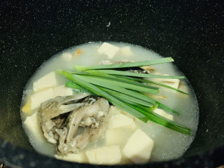 奶白鲫鱼豆腐汤,最后加入蒜苗叶，用大勺子舀汤汁，浇在蒜叶上，断生就可以了；