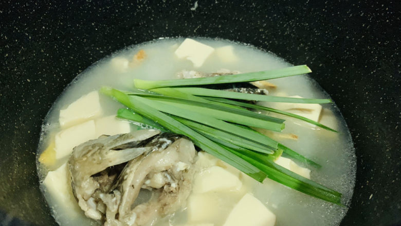 奶白鲫鱼豆腐汤,最后加入蒜苗叶，用大勺子舀汤汁，浇在蒜叶上，断生就可以了；