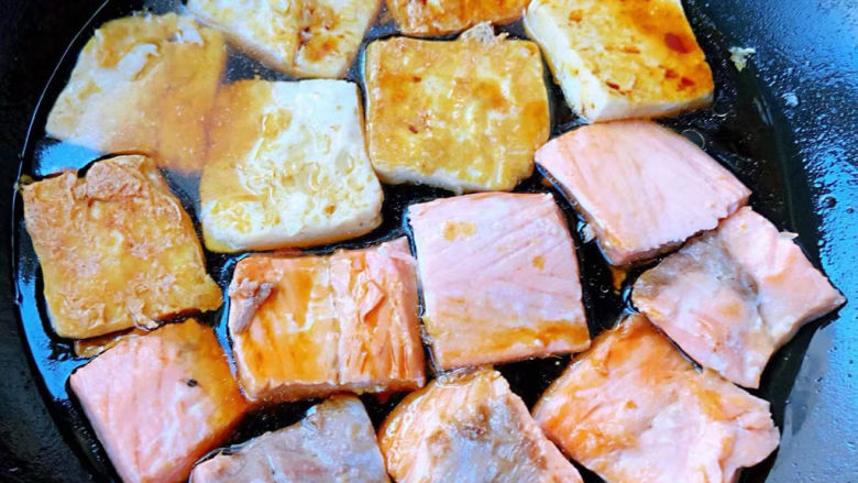 红烧三文鱼,豆腐放入锅中淋上调好的红烧汁同时也可以添加少许清水中小火煎