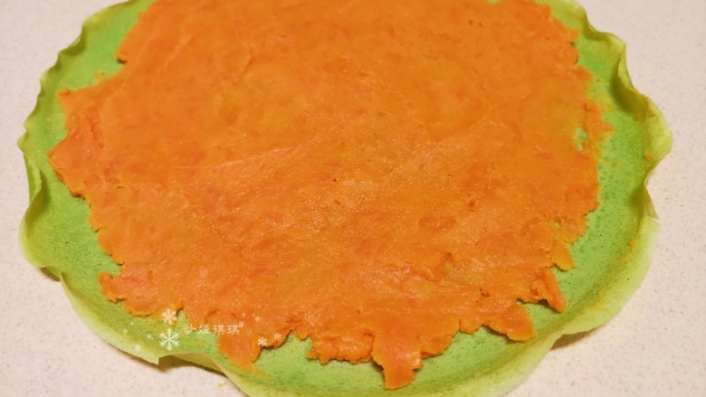 菠菜蛋卷,将红薯泥平铺在菠菜鸡蛋饼皮上。