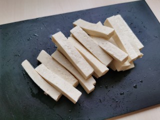 韭菜炒豆腐,豆腐先切成片状，然后再切成豆腐条。豆腐条不要切的太细，容易炒碎。