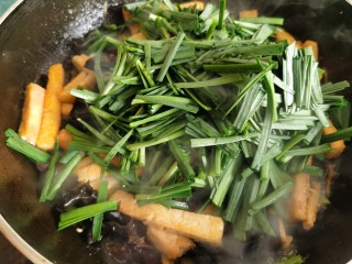 韭菜炒豆腐,最后加入韭菜段翻炒。