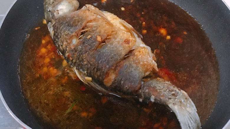 酱焖鲫鱼,放入煎好的鲫鱼焖煮，其间时不时用汤汁浇到鲫鱼上面。