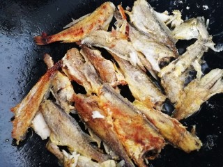 红烧小黄鱼,逐条放入油锅内，文火煎4分钟左右翻面。