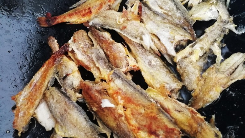红烧小黄鱼,逐条放入油锅内，文火煎4分钟左右翻面。