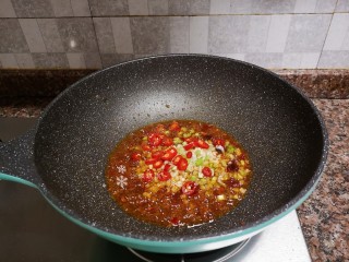 酱焖鲫鱼,放入辣椒、葱头、大蒜翻炒出香味。
