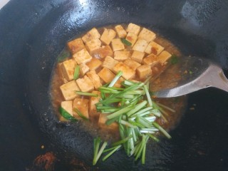 韭菜炒豆腐,水快耗干时，放入韭菜根部翻炒