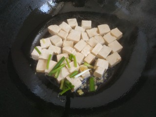 韭菜炒豆腐,放入葱姜