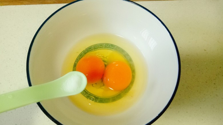 菠菜蛋卷,碗中打入鸡蛋，加入一小勺盐，用手动打蛋器搅打均匀