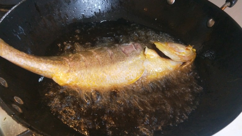 酱焖鲫鱼,油温7成热下入油锅炸制。