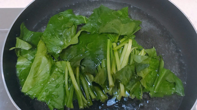 菠菜豆腐汤,把菠菜放进加了食用油的开水中焯水一分钟后捞起