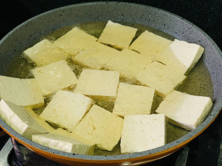 韭菜炒豆腐,将全部豆腐放入油里，不要重叠放；