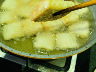 韭菜炒豆腐,中小火，把豆腐两面煎金黄，就可以捞出油锅，煎的过程如果会溅油，再把火调小点；