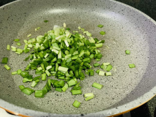韭菜炒豆腐,先把韭菜根白倒入锅里；