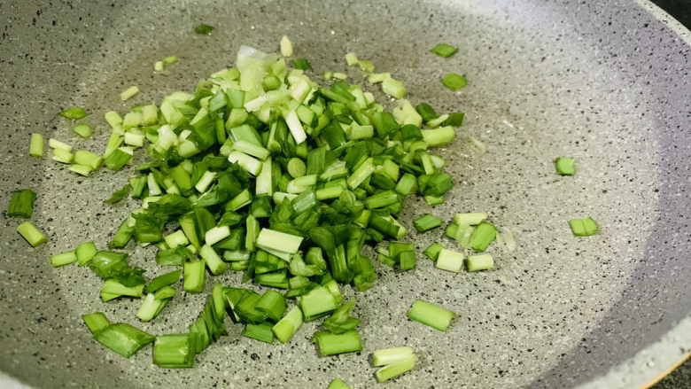 韭菜炒豆腐,先把韭菜根白倒入锅里；