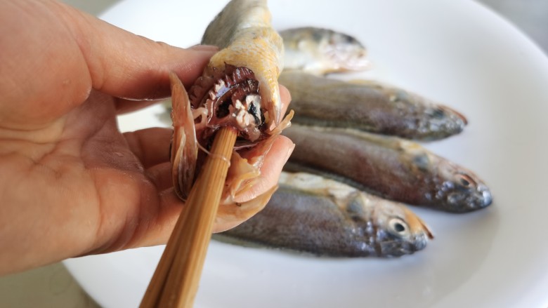 红烧小黄鱼,然后转动筷子一拧，所有内脏及鱼鳃就都出来了。