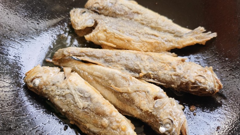 红烧小黄鱼,别着急翻动它，当煎至小黄鱼定型且成金黄色时，翻过来再煎另一面。两面都煎好后盛出备用。