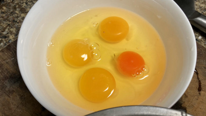 香椿炒蛋,鸡蛋打入碗中