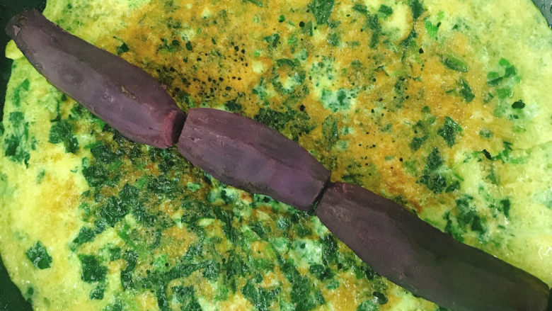 菠菜蛋卷,将提前煮好的小紫薯剥皮后整齐的放在蛋饼上